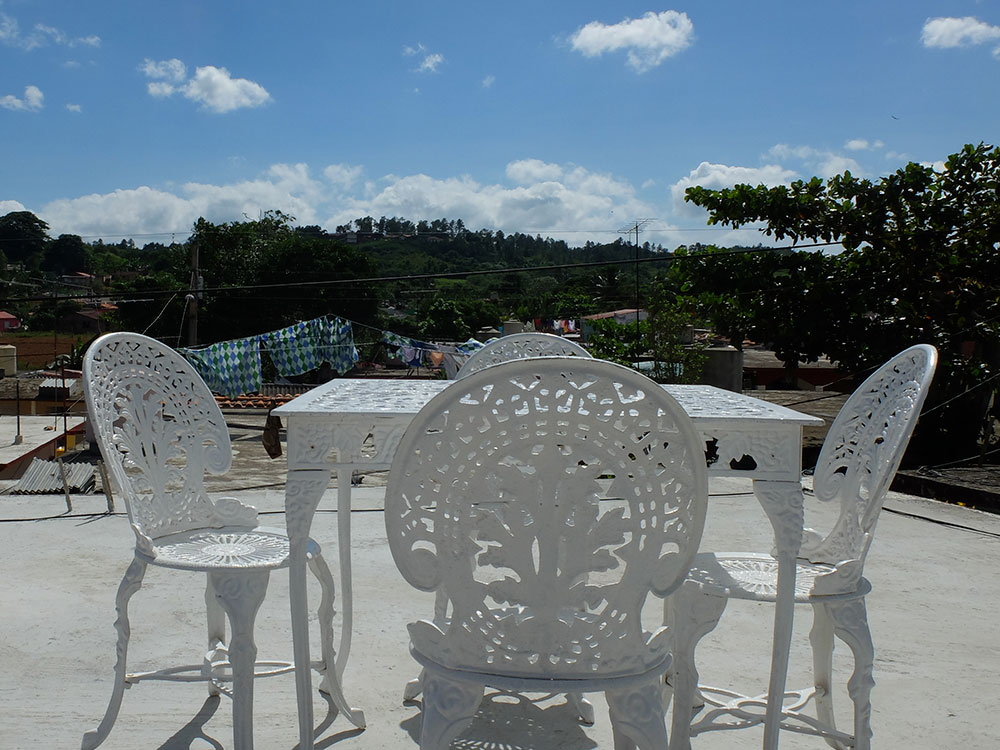 Terrace of Casa Eusebia y Eusebio, Casa particular in Viñales, with a table and four iron chairs and a view of the mogotes