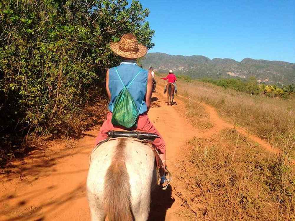 Turista a caballo con guía en el Parque Nacional Viñales